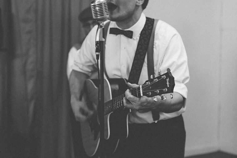 close up of man playing a guitar, photo is black and white