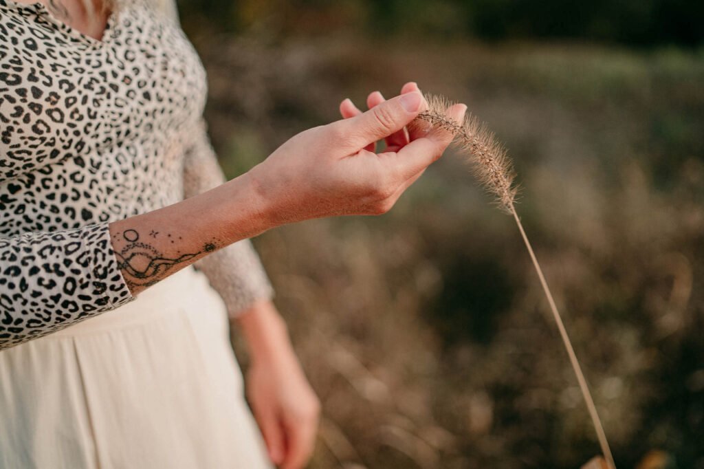 close up of hand touching long field grass