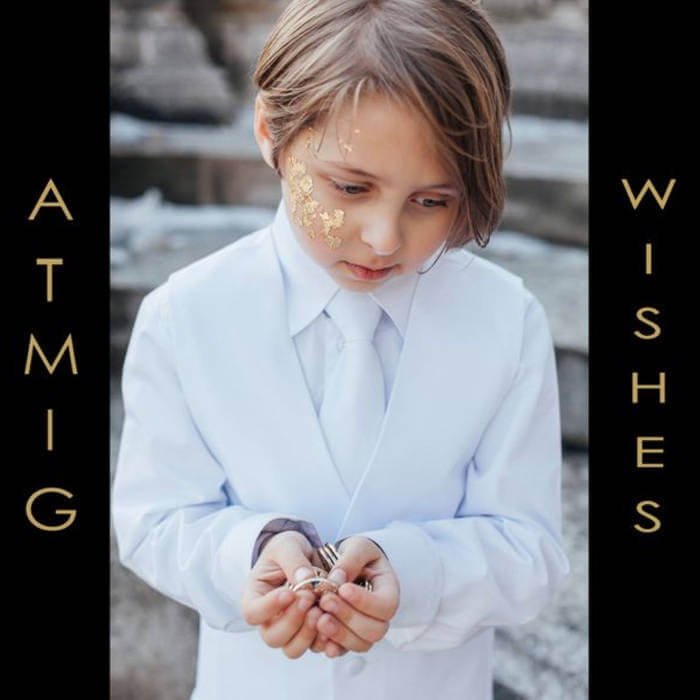 Boy wearing white suit holding gold coins, album cover for band