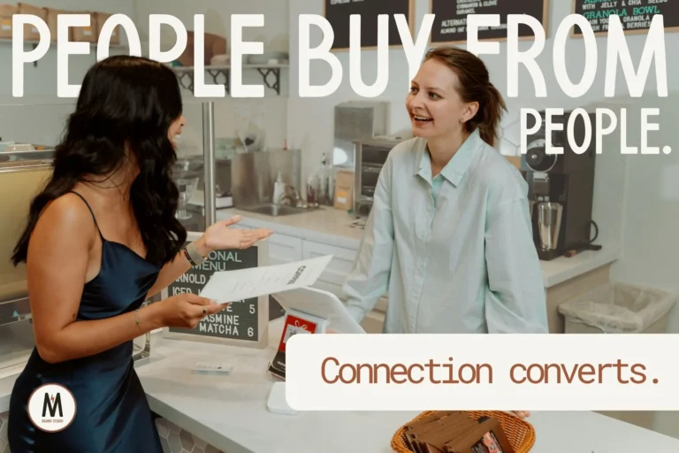 Two women engaged in a friendly conversation at a café counter, illustrating genuine connection and trust in small business.